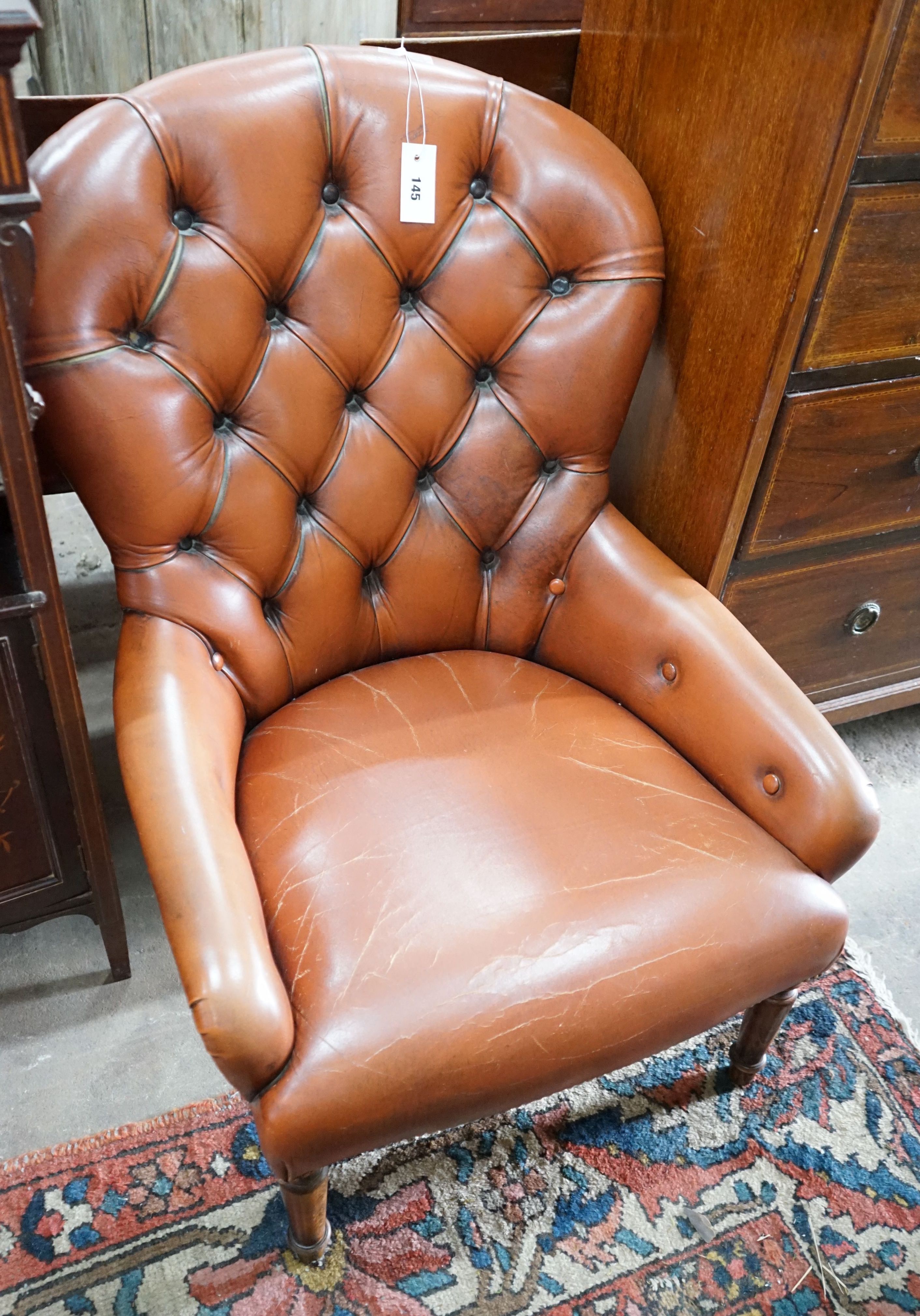 A modern buttoned brown leather easy chair, width 64cm, depth 70cm, height 85cm